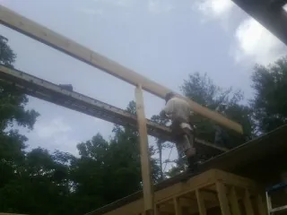 Carpenter setting a ridge beam over a new addition frame — Ice Dam Removal by Roofing Brothers in Masontown